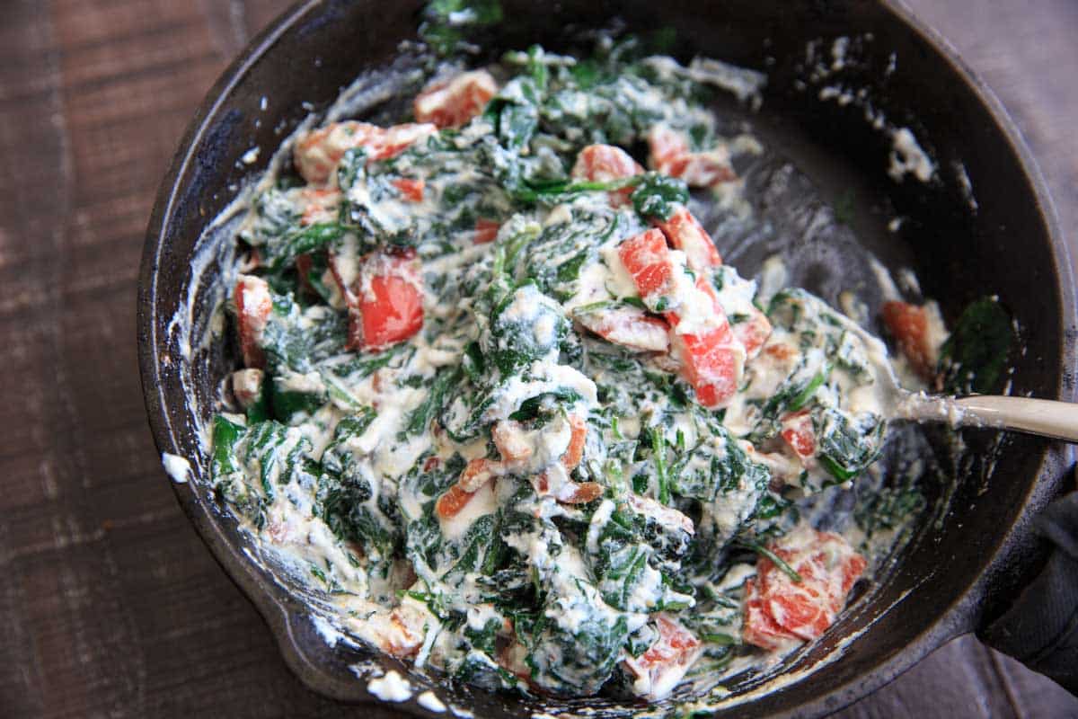 sauteed spinach and bell pepper with ricotta mixed together in cast iron pan - Spinach Ricotta Crescent Wrap