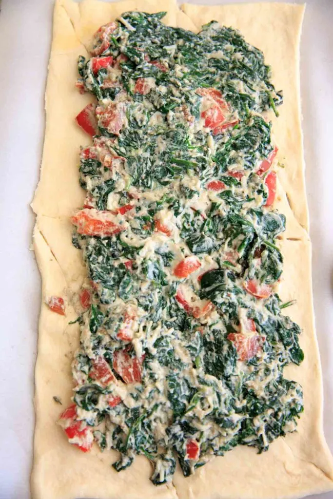 Spinach ricotta mixture spread on crescent wrap before braiding- Spinach Ricotta Crescent Wrap
