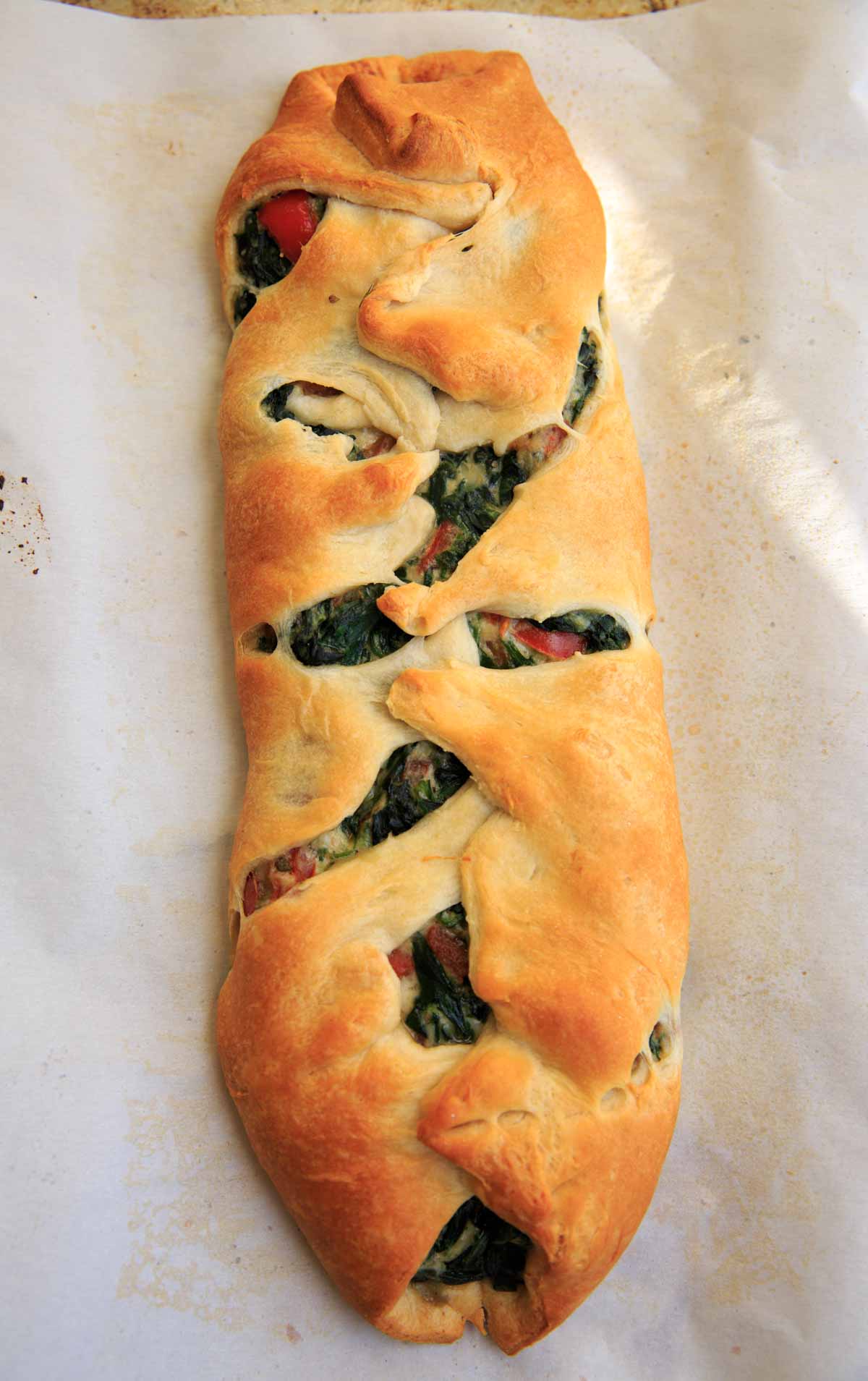 Baked and braided spinach ricotta mixture on crescent wrap - Spinach Ricotta Crescent Wrap
