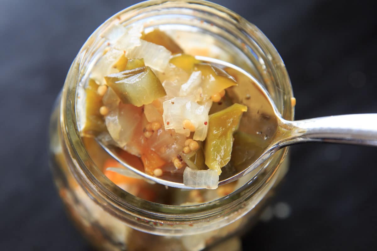 scoop of sweet pickle relish on spoon out of mason jar
