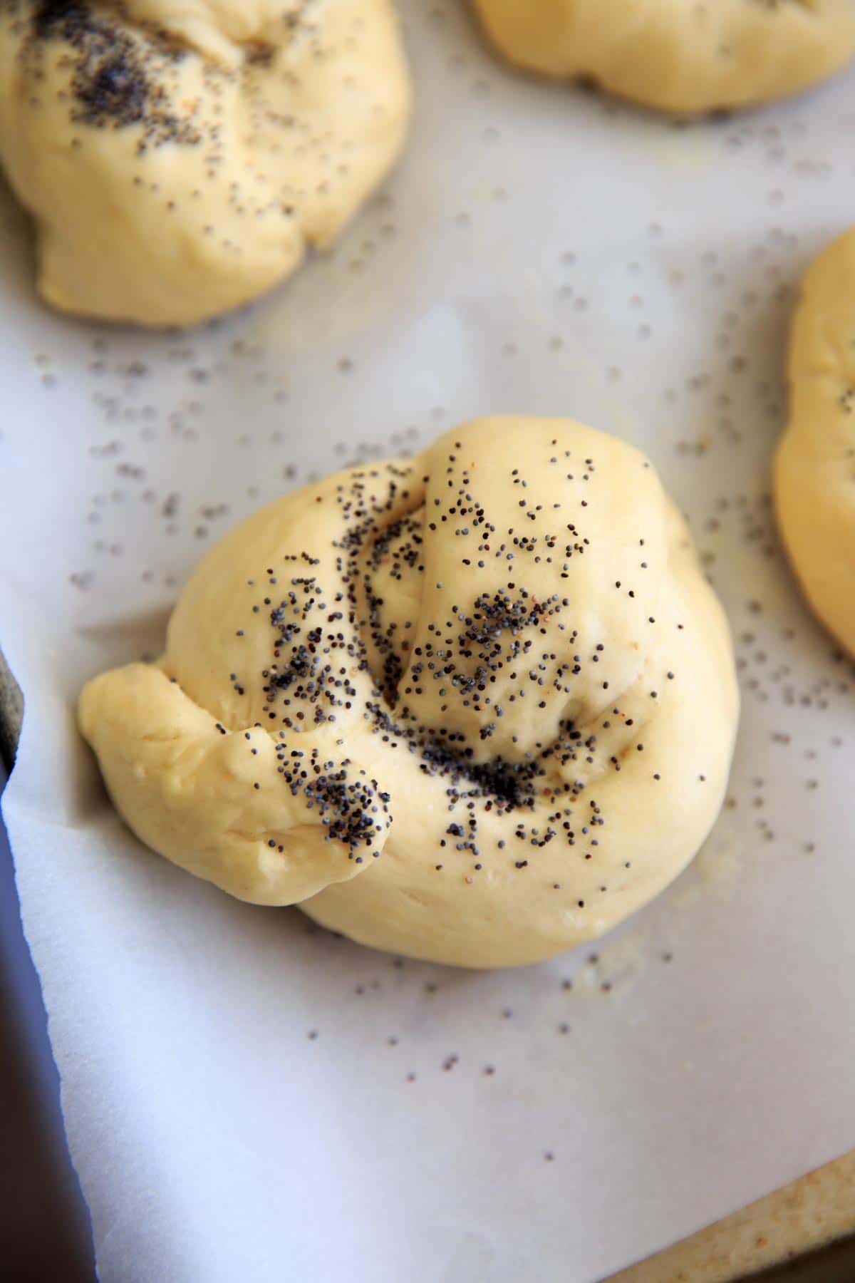 Homemade Kaiser Rolls Recipe - roll before baking with poppy seeds