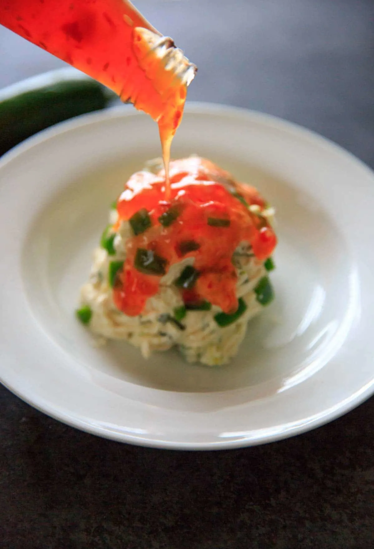 Pouring sweet chili sauce over the jalapeno cream cheese ball
