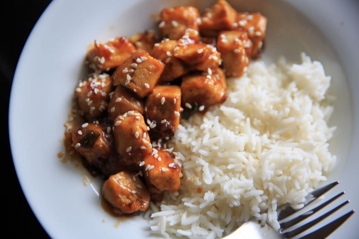 General Tso's Tofu with rice on white plate