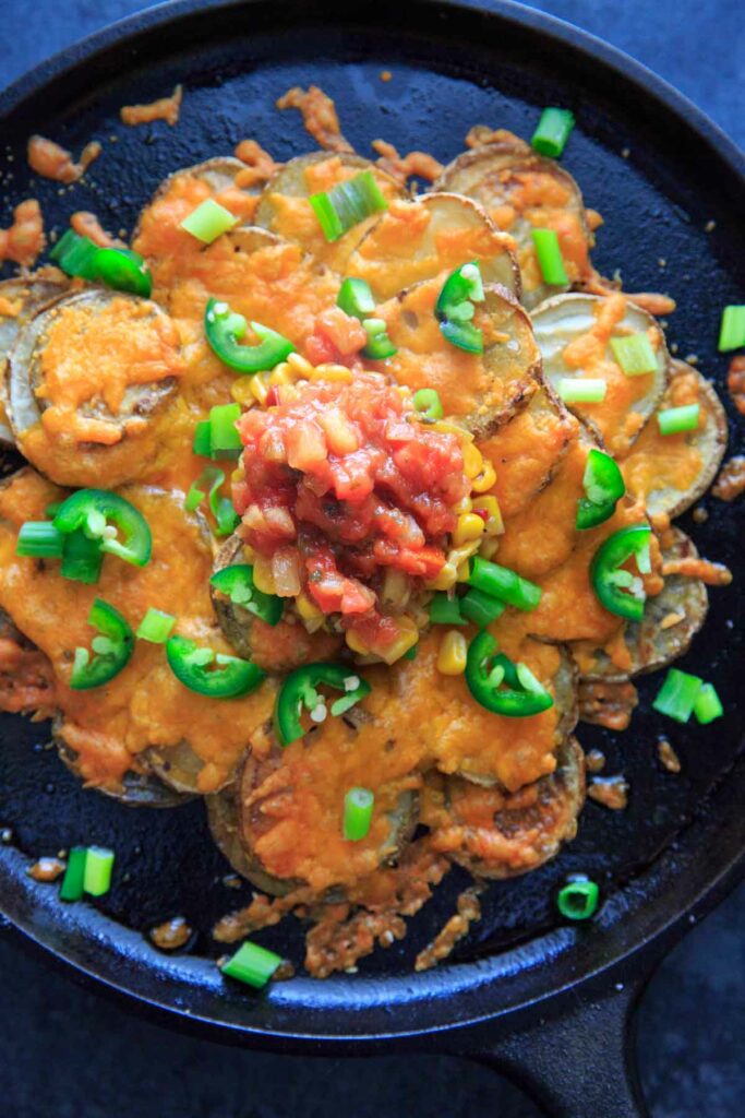 pub nachos with cheese and toppings in cast iron