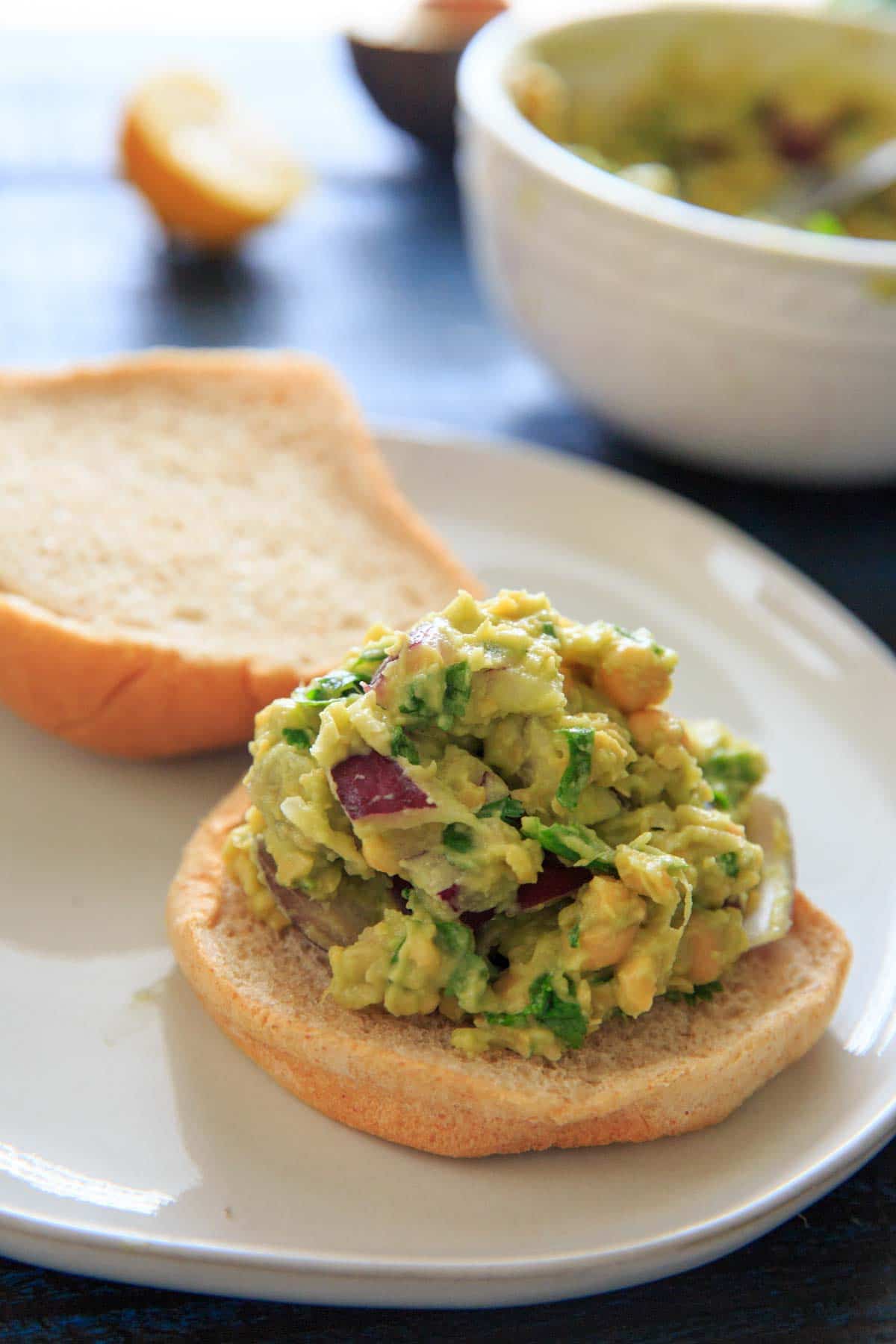 Smashed Avocado and Chickpea Salad sandwich on a bun open-faced
