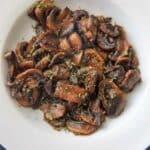 Chili White Button Mushrooms - sliced mushrooms caramelized in garlic and olive oil, topped with chili flakes and parsley. A deliciously easy, spicy and unexpected veggie side dish!