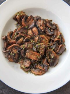 Chili White Button Mushrooms - sliced mushrooms caramelized in garlic and olive oil, topped with chili flakes and parsley. A deliciously easy, spicy and unexpected veggie side dish!