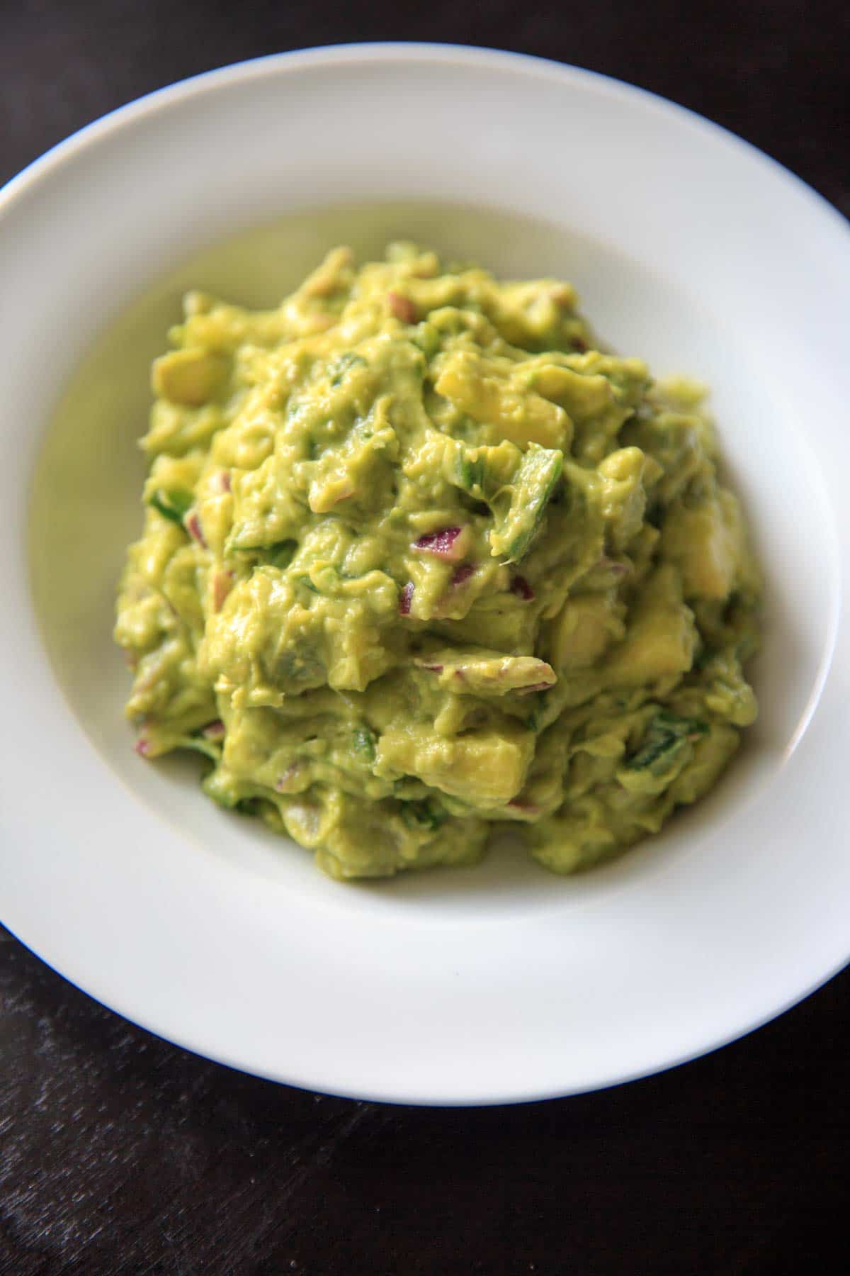 Pineapple Jalapeno Guacamole mashed up on white bowl