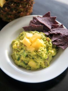 Pineapple Jalapeno Guacamole is a tropical spin on this favorite appetizer dip. Great for summer gatherings, cookouts and gatherings! Serve this vegan and gluten-free snack with corn chips, crackers or veggies.