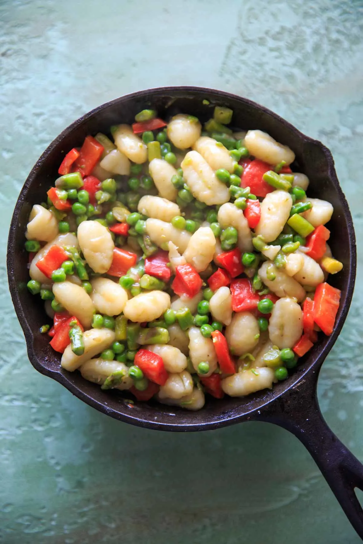 gnocchi and veggies in cast iron pan cooking