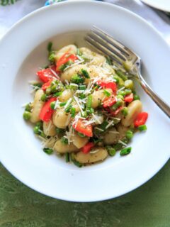 Spring Vegetable Gnocchi with asparagus, peas and herbs. Option to add a touch of parmesan cheese or leave off to keep it vegan! A delicious and fresh tasting pasta dish that's not too heavy and loaded with veggies.