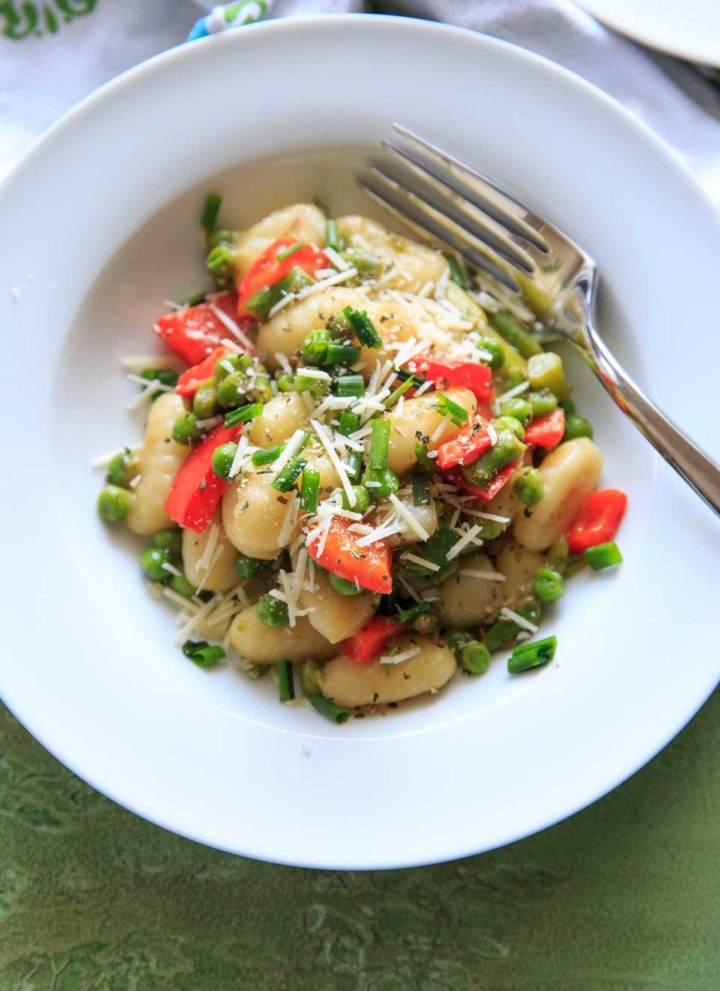 Spring Vegetable Gnocchi with asparagus, peas and herbs. Option to add a touch of parmesan cheese or leave off to keep it vegan! A delicious and fresh tasting pasta dish that's not too heavy and loaded with veggies.