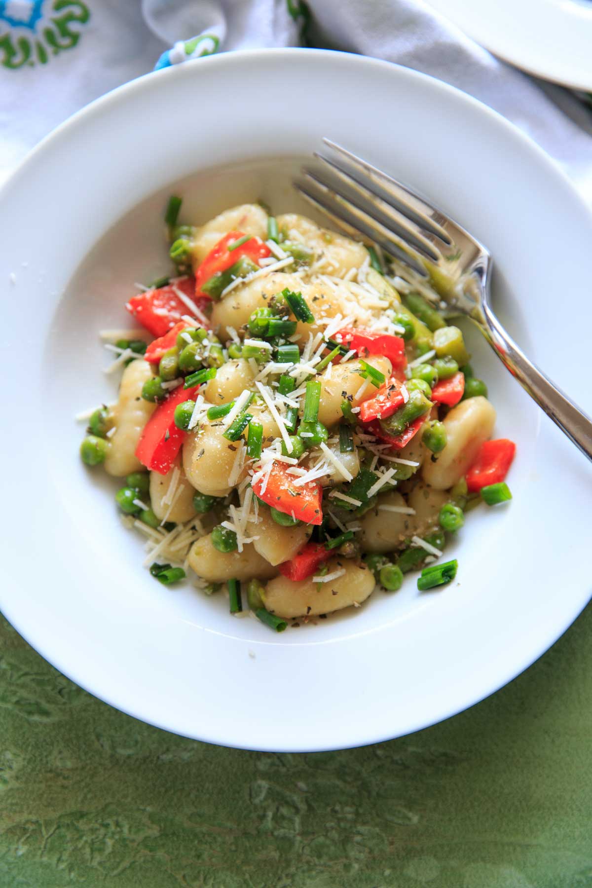 spring vegetable gnocchi with shredde cheese on top