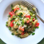 Spring Vegetable Gnocchi with asparagus, peas and herbs. Option to add a touch of parmesan cheese or leave off to keep it vegan! A delicious and fresh tasting pasta dish that's not too heavy and loaded with veggies.