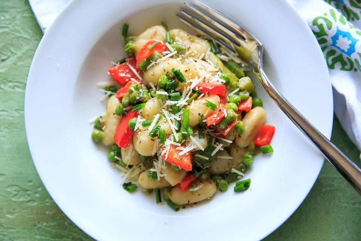 One-pot Spring Vegetable Gnocchi with asparagus, peas and herbs, ready in 15 minutes! Option to add a touch of parmesan cheese or leave off to keep it dairy-free! A delicious and fresh tasting pasta dish that's not too heavy, and loaded with veggies.