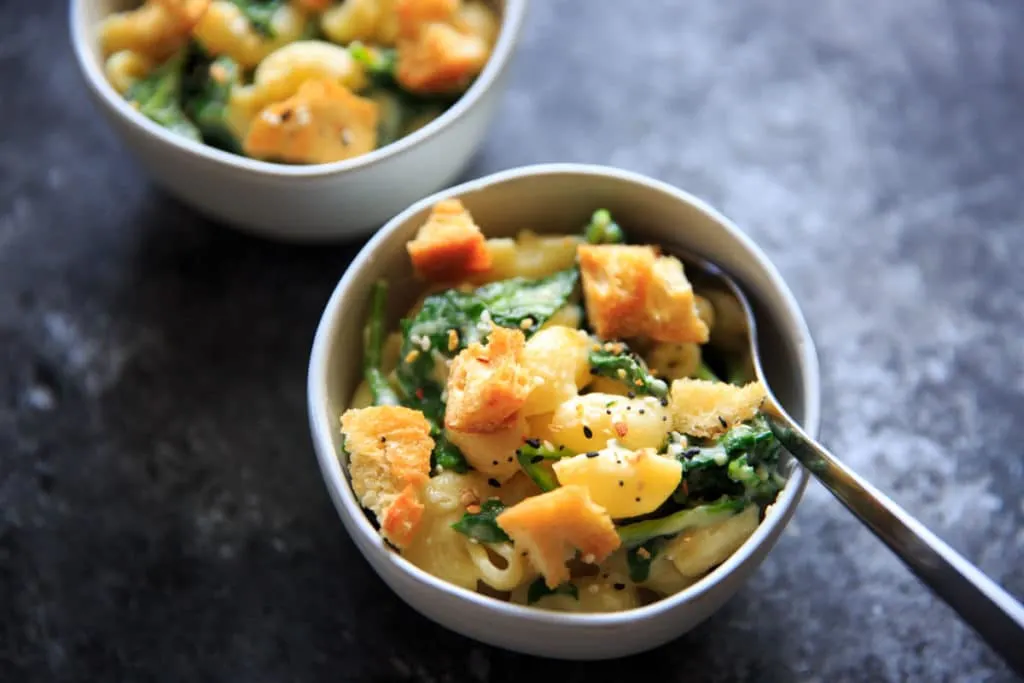 White Cheddar Macaroni and Cheese with Spinach and "Everything Bagel" Seasoned croutons. A delicious and unique spin on mac and cheese that comes together surprisingly quickly - in under 30 minutes! This flavorful combo sneaks in veggies and is sure to be added to your meatless dinner rotation.