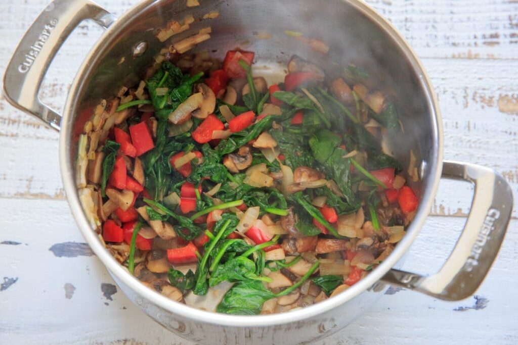 Gluten-free zucchini noodle vegetable lasagna, sautéing the spinach, bell pepper and onions.