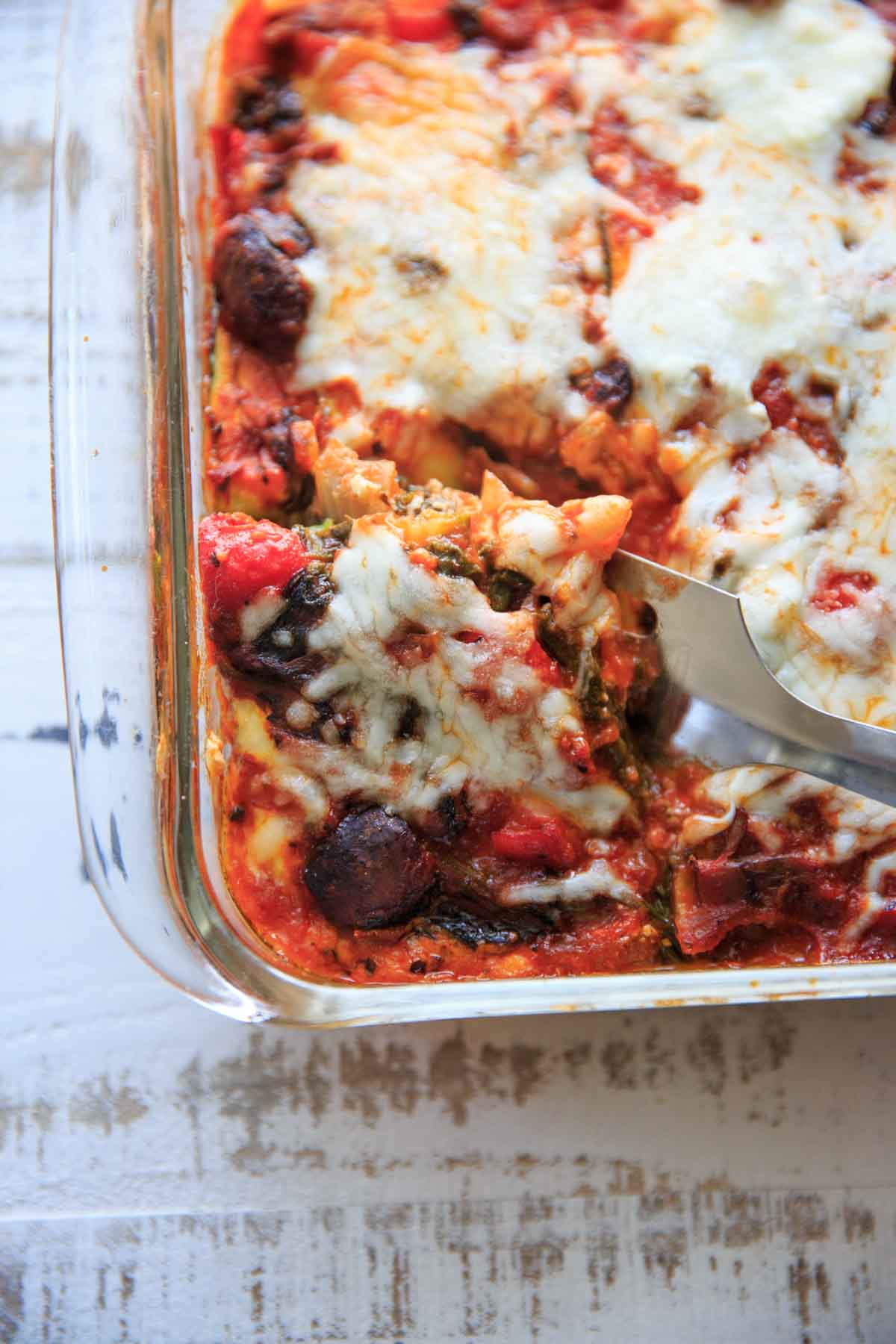 spatula cutting out a piece of zucchini noodle veggie lasagna from baking dish