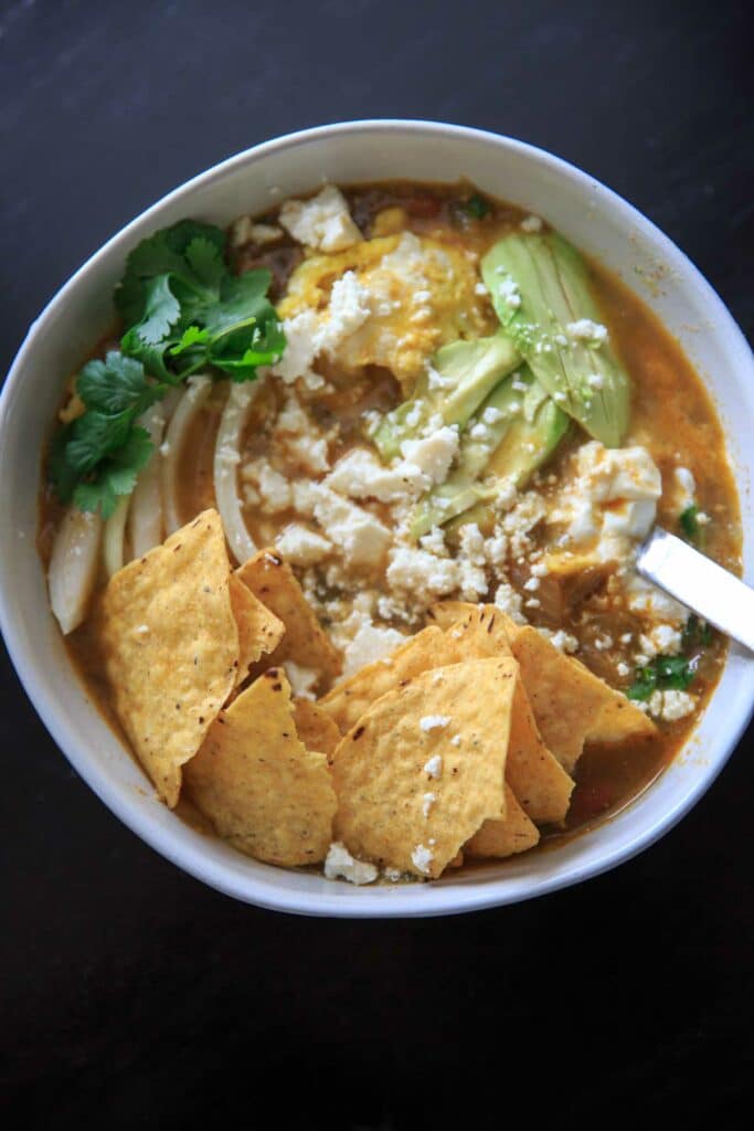 Finished dish chilaquiles verdes with soft-scrambled eggs, avocado and queso fresco