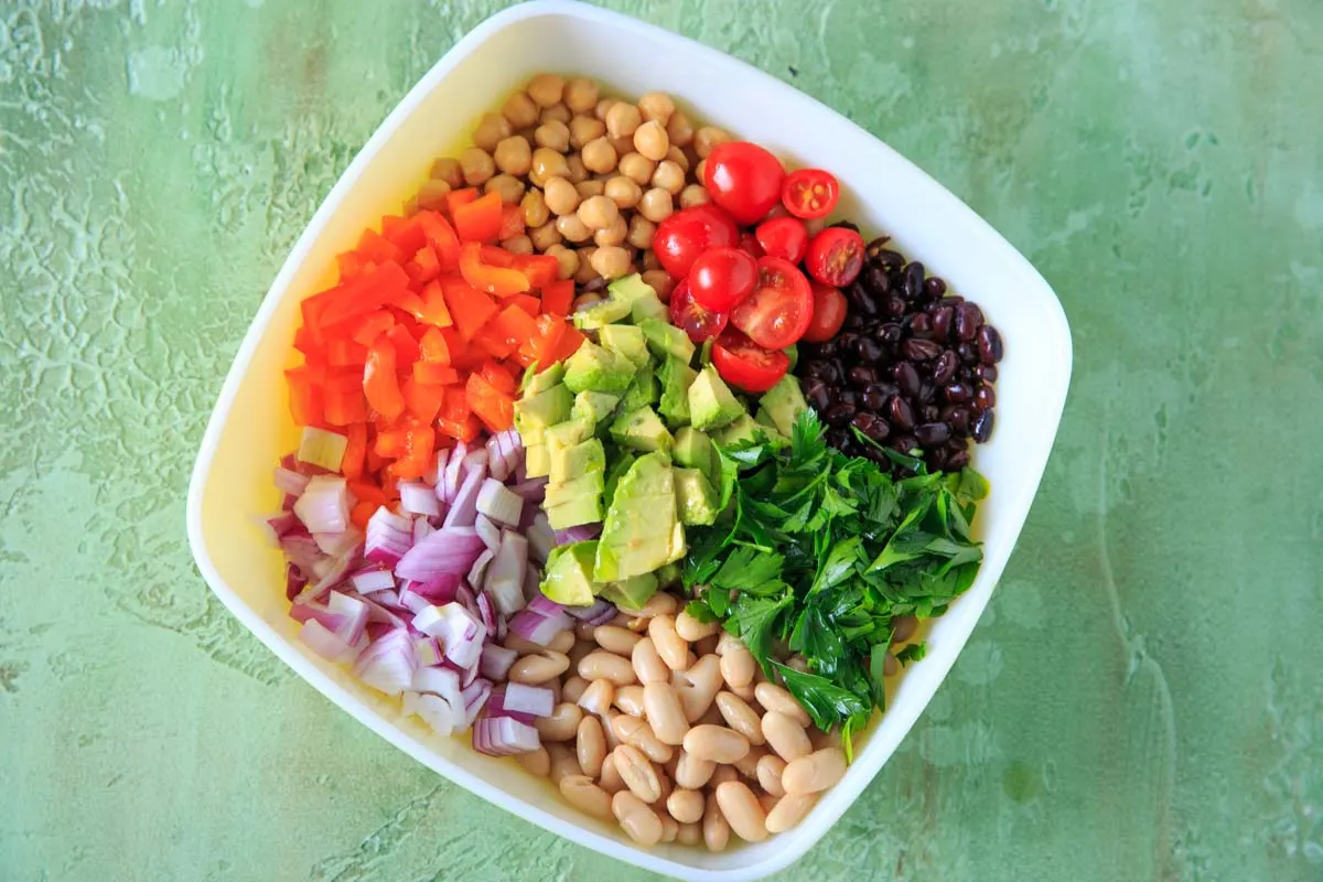 Three Bean Salad with avocado, vegetables and herbs. A flavorful vegan and gluten-free side dish perfect for a picnic or potluck, and filling enough for a main dish!