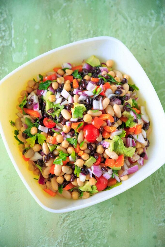 Three Bean Salad with avocado, vegetables and herbs in a large bowl