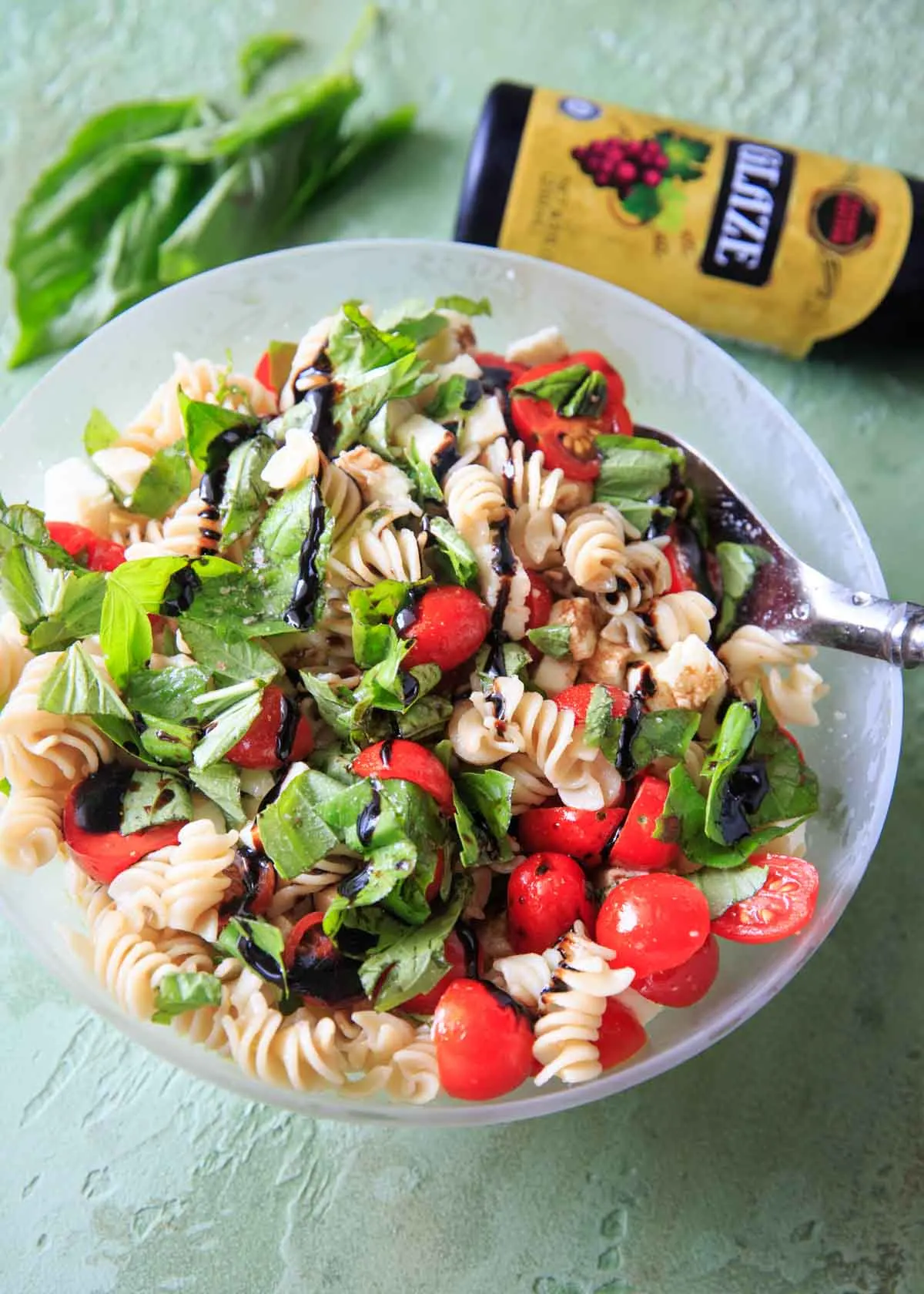 Caprese Pasta Salad topped with balsamic glaze