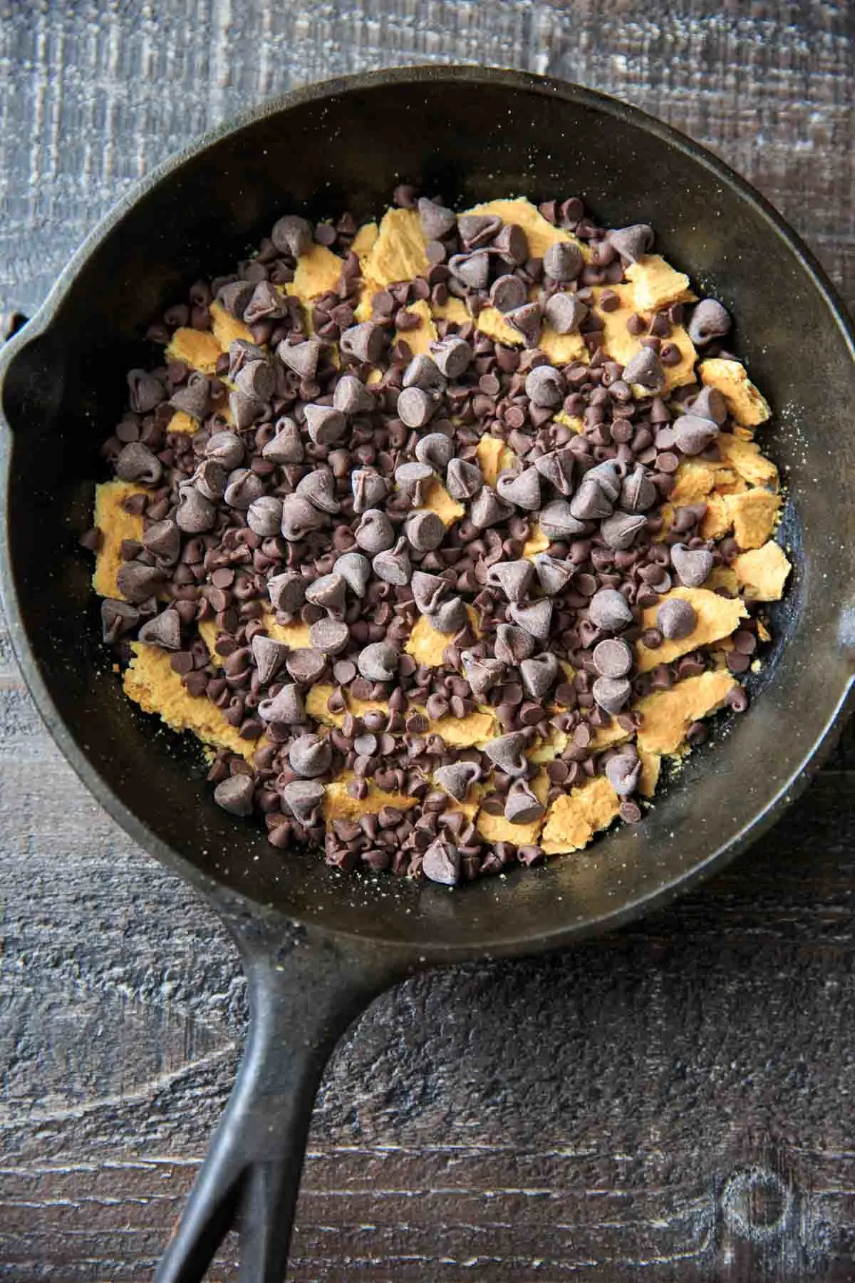 Crumbled graham crackers and chocolate chips ( regular and mini chips) in a cast iron pan