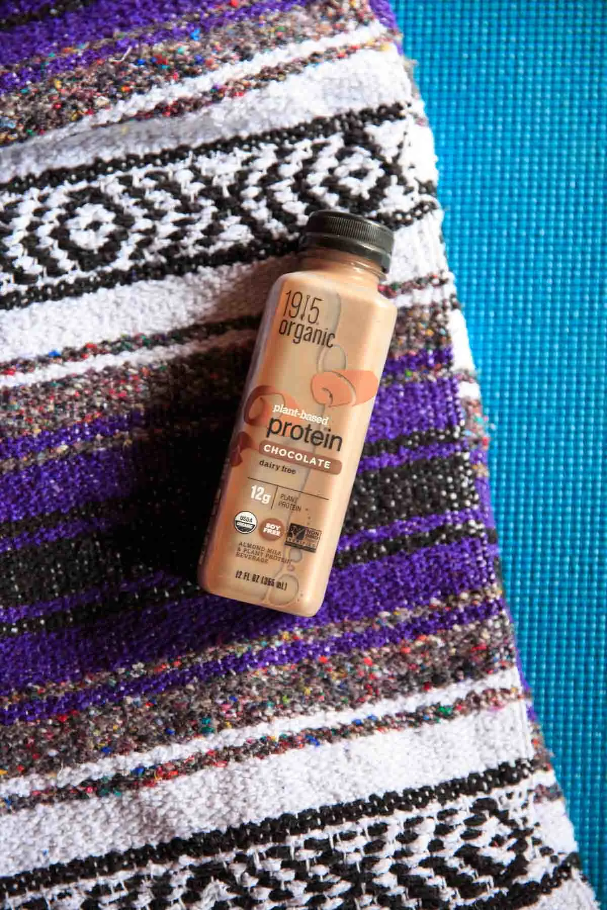 1915 Organic Protein Drink - Chocolate on yoga mat and blanket