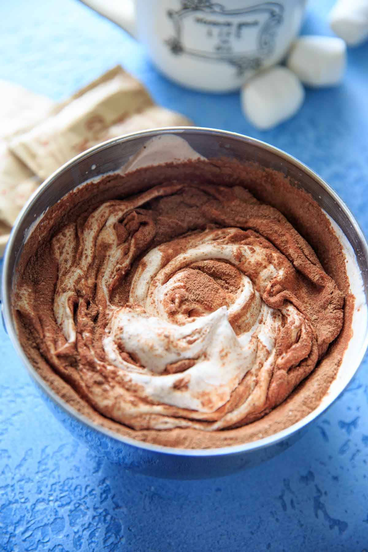Mixing Hot cocoa powder in whipped whipping cream in mixing bowl
