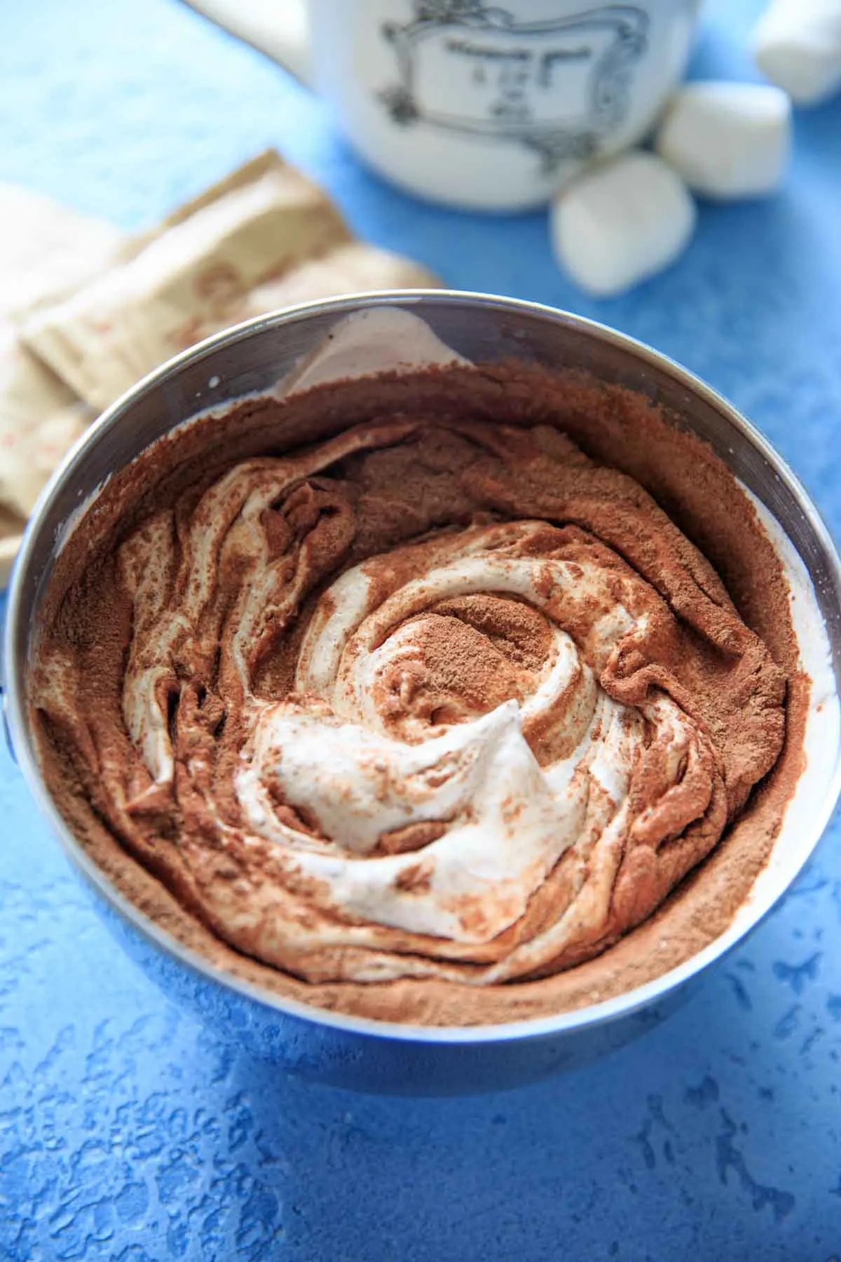 Mixing Hot cocoa powder in whipped whipping cream in mixing bowl