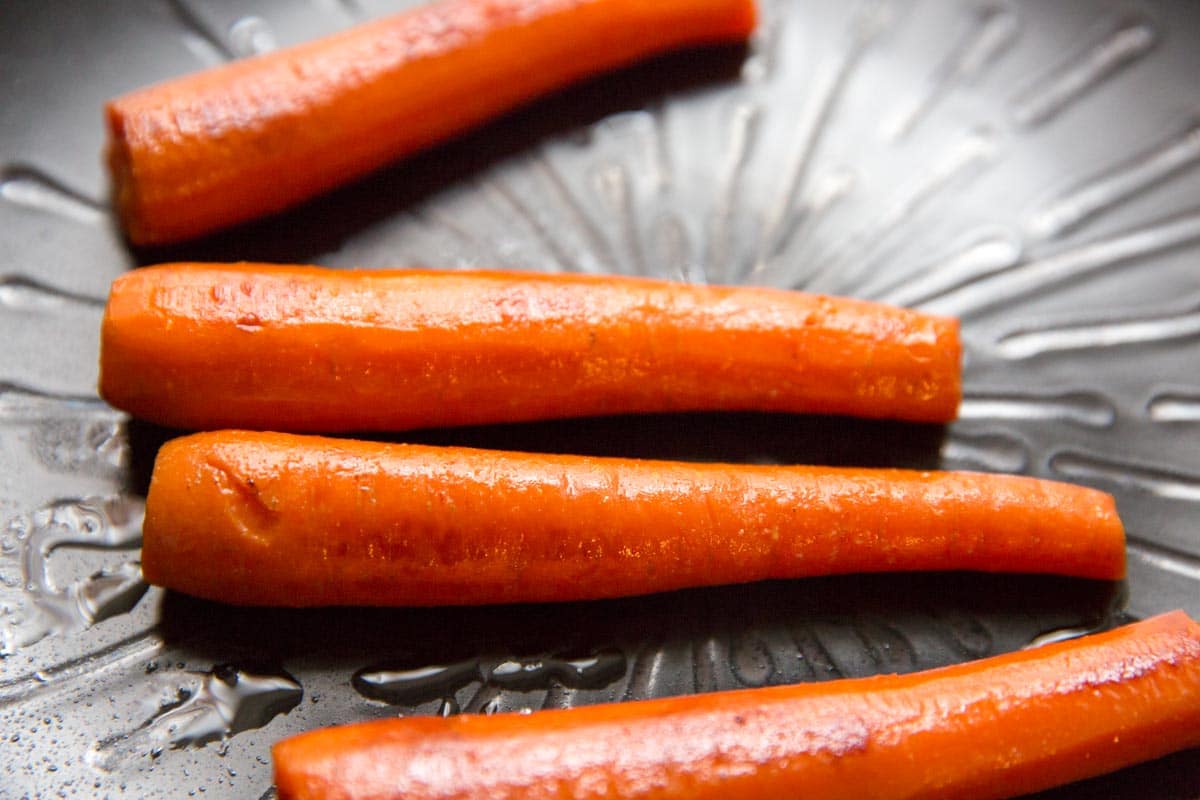 cooked carrots on black plate 