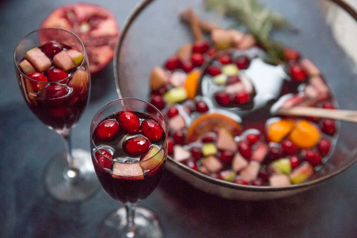 Holiday Sangria in two glasses next to serving bowl