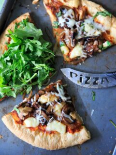 Homemade pizza with caramelized onions, fresh baby arugula and brie cheese!