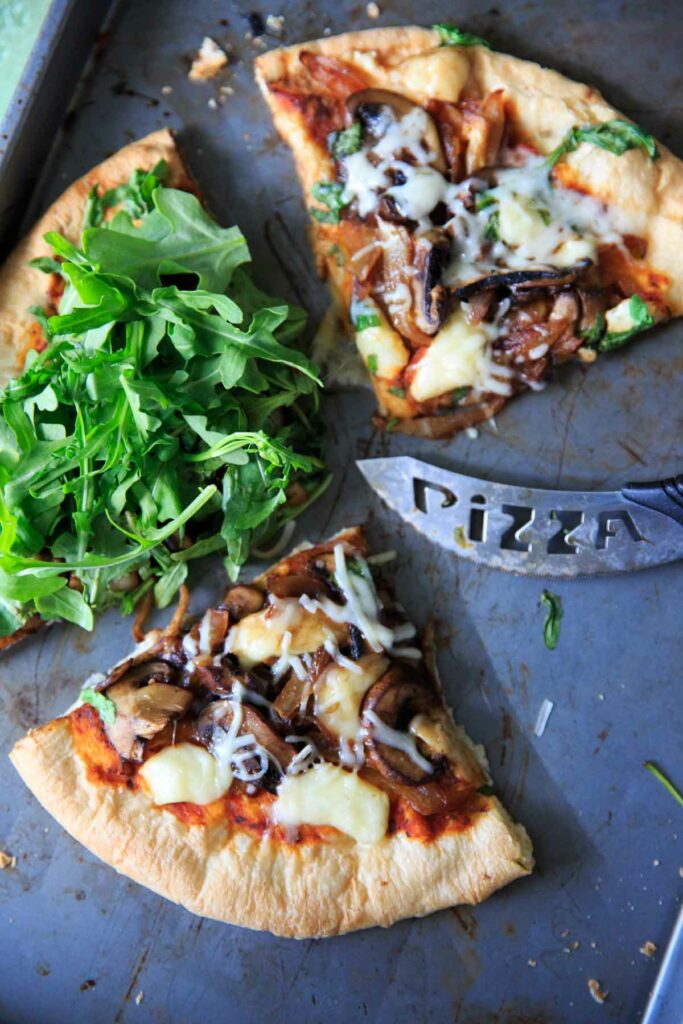 Homemade pizza with caramelized onions, fresh baby arugula and brie cheese! 