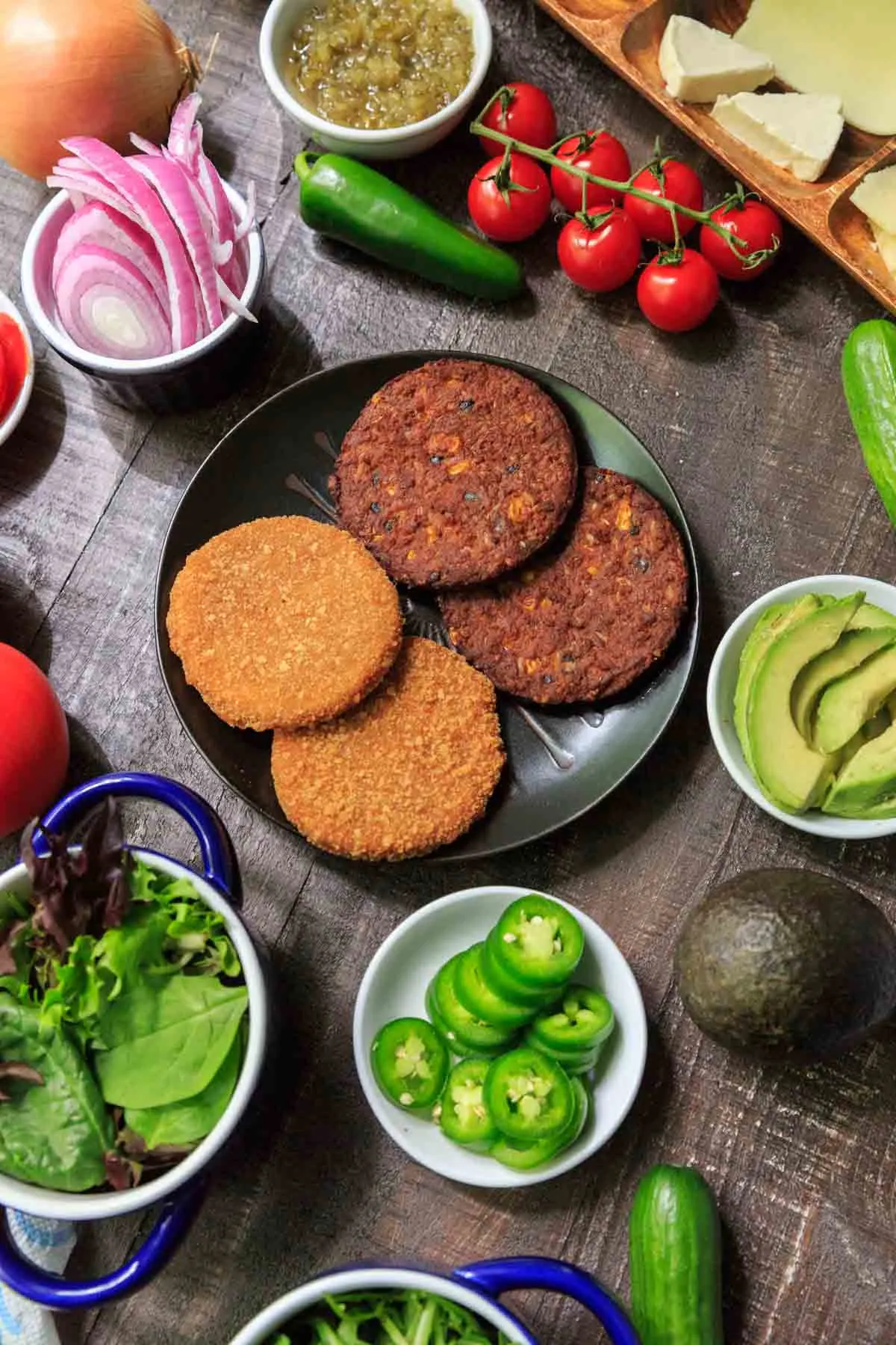 MorningStar burgers on black plate surrounded by topping options