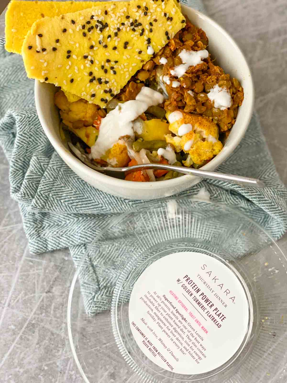 Sakara protein power plat in bowl, turmeric flatbread on side