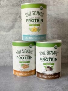 3 canisters of four sigmatic protein powders - peanut butter, sweet vanilla, creamy cacao