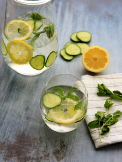 pitcher of spa water with cucumber, lemon and mint and drinking glass