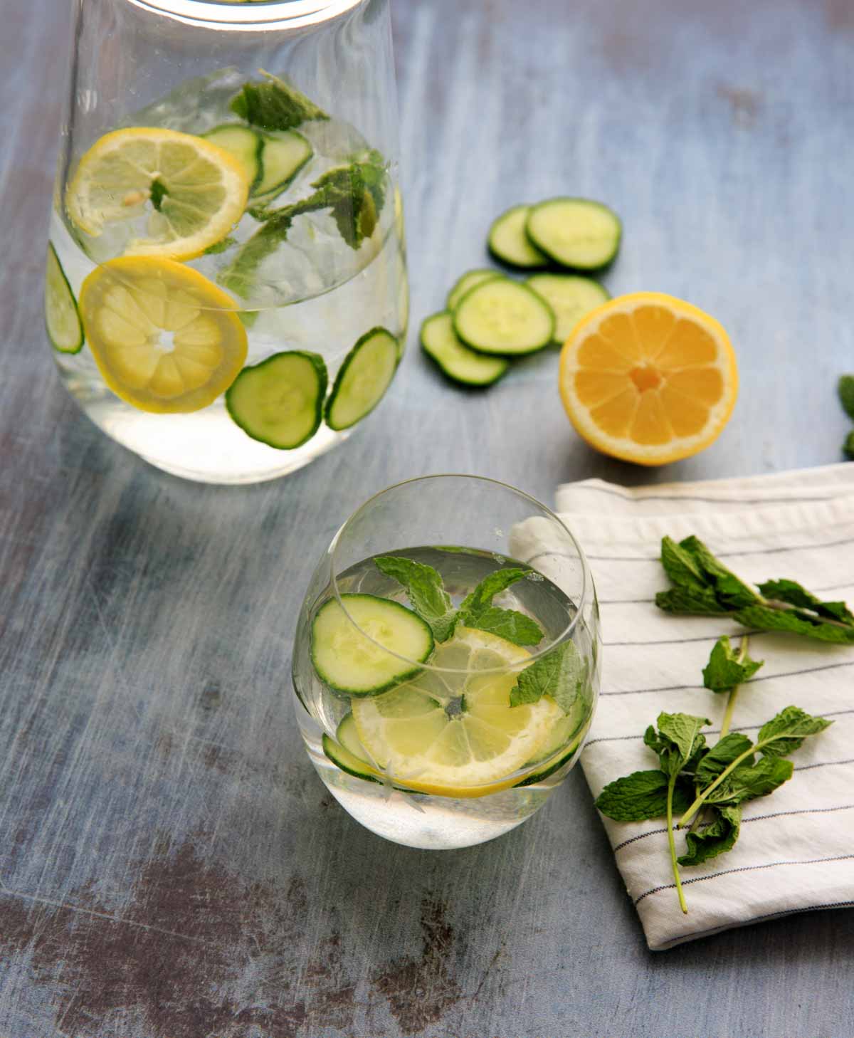 pitcher of spa water with cucumber, lemon and mint and drinking glass