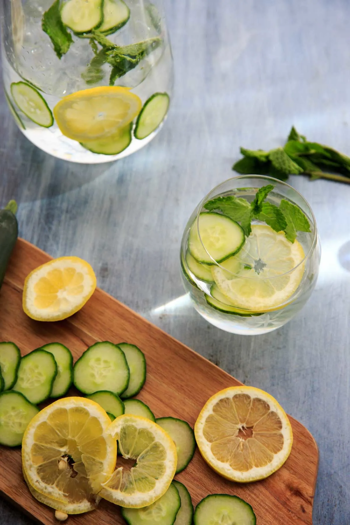 cucumber, lemon mint water in glasses with slices on cutting board