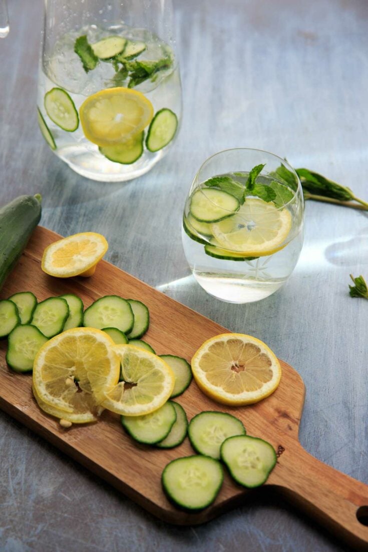 cucumber, lemon mint water in glasses with slices on cutting board