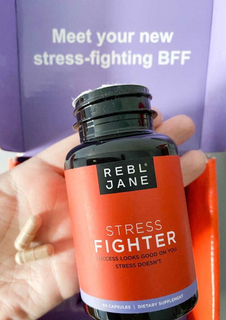 Holding Rebl Jane Stress Fighter bottle and two capsules