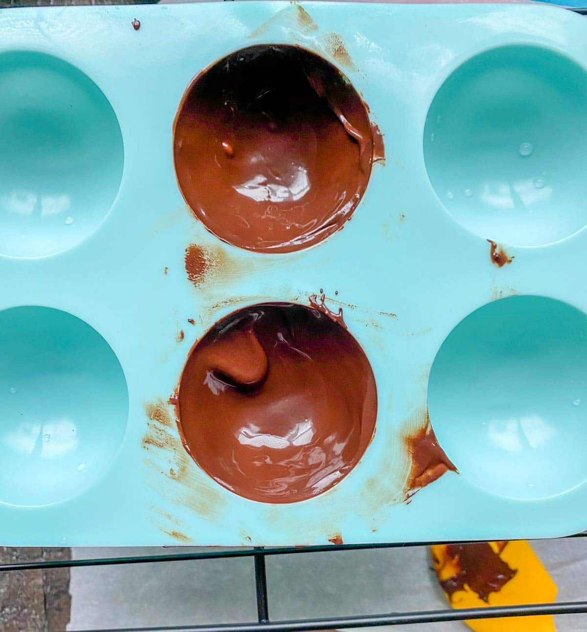making hot chocolate bombs, melted chocolate in silicone sphere molds
