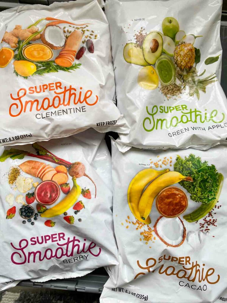 four bags of SmoothieBox smoothies, one in each flavor - clementine, apple with greens, berry, cacao