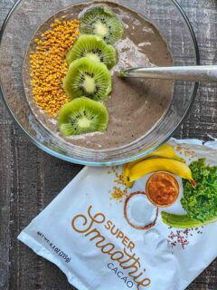 SmoothieBox Cacao flavor super-smoothie in a smoothie bowl, topped with kiwi slices and bee pollen