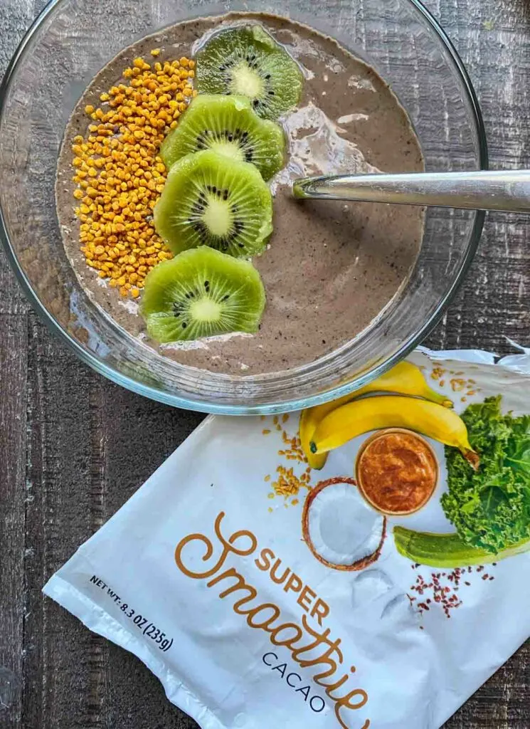 SmoothieBox Cacao flavor super-smoothie in a smoothie bowl, topped with kiwi slices and bee pollen