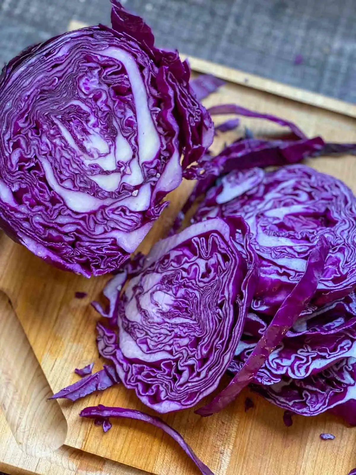 slicing up purple cabbage on cutting board