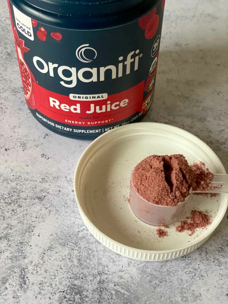 organifi red juice powder in jar with a scoop out shown on lid