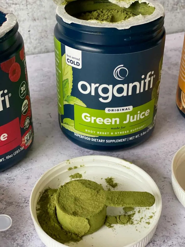 organifi green juice powder in jar with a scoop out shown on lid