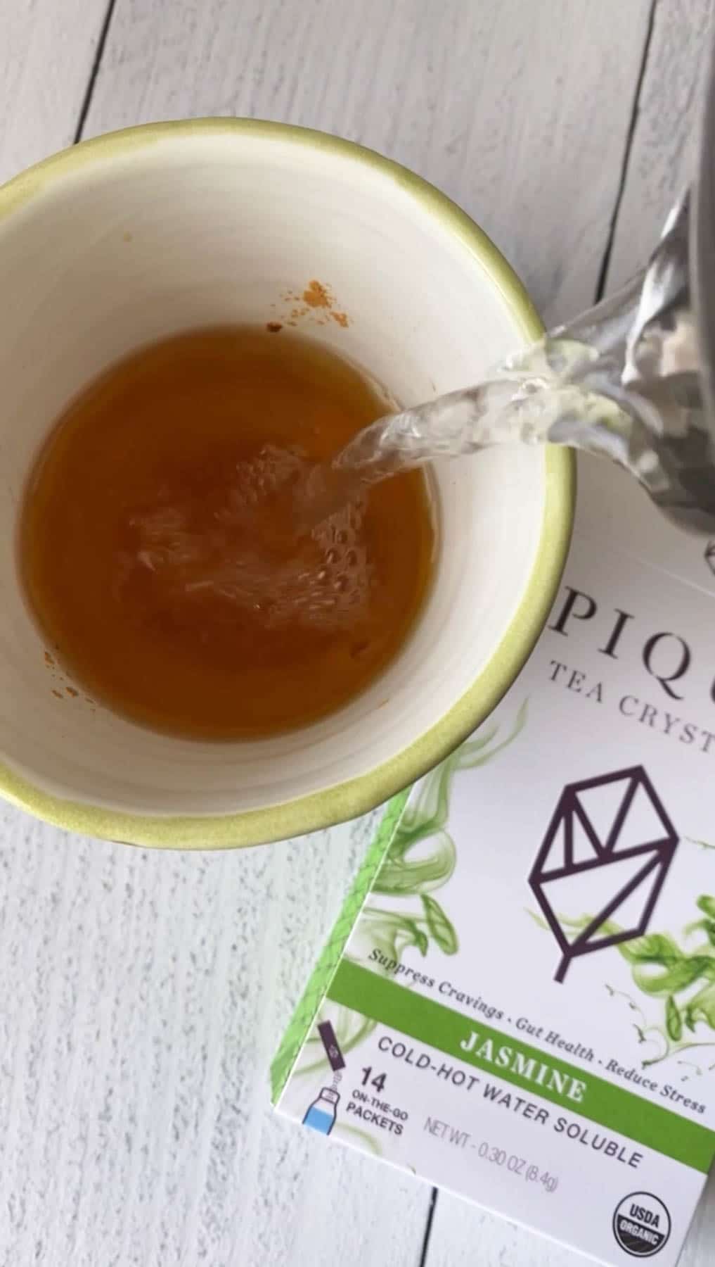 pouring hot water in a cup of pique jasmine tea